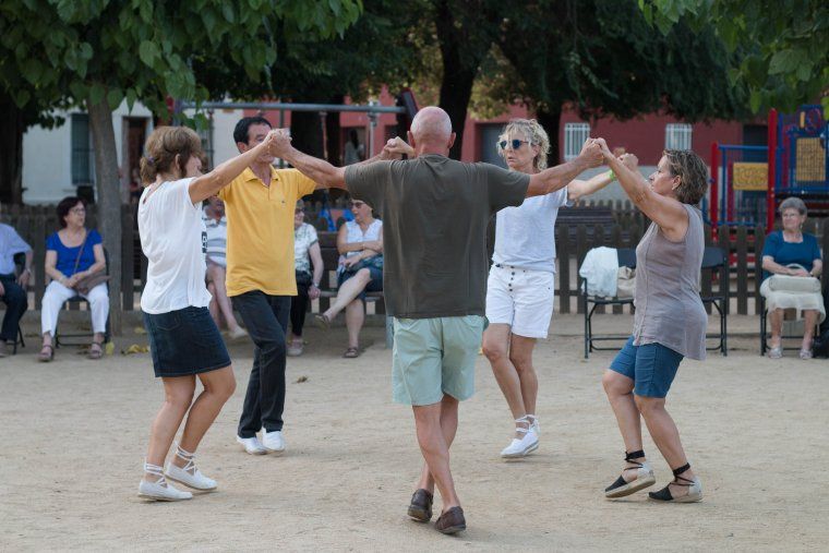 Els veïns del barri dansant a la plaça