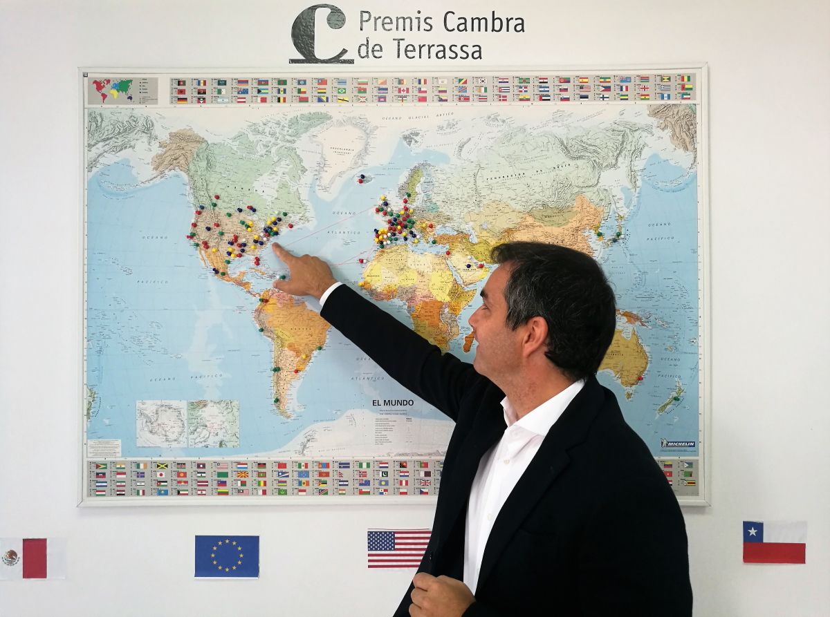 Xavier Garrido davant del mapa que mostra tots els llocs del món on ha arribat o arribarà Robin Hat