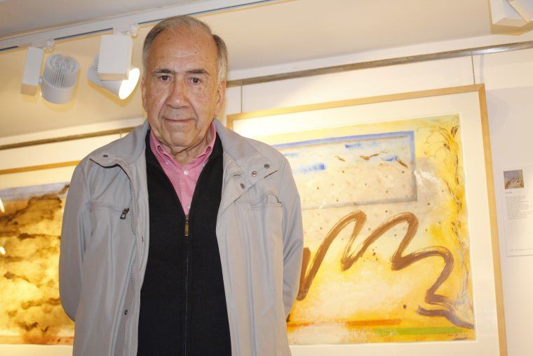 El poeta Joan Margarit al costat d'un quadre de l'exposició de Sergi Marcos