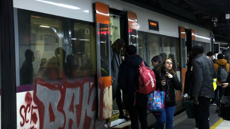 Un tren de Rodalies a l'estació de Sants amb viatgers pujant i baixant del comboi