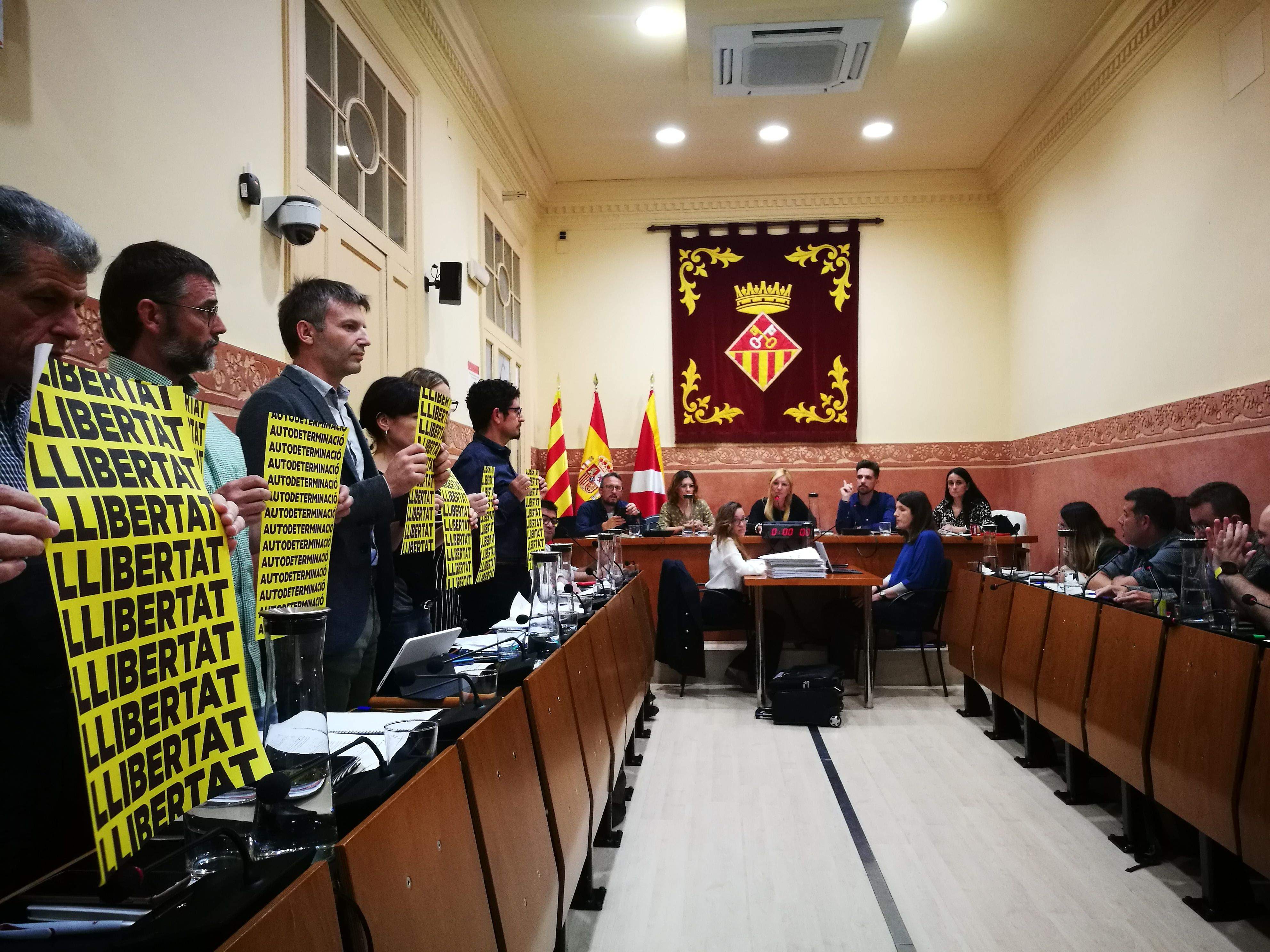 Els regidors dels grups municipals d’ERC i AUP aixequen pancartes a l'inici del pel municipal d'aquest dijous. FOTO: Redacció