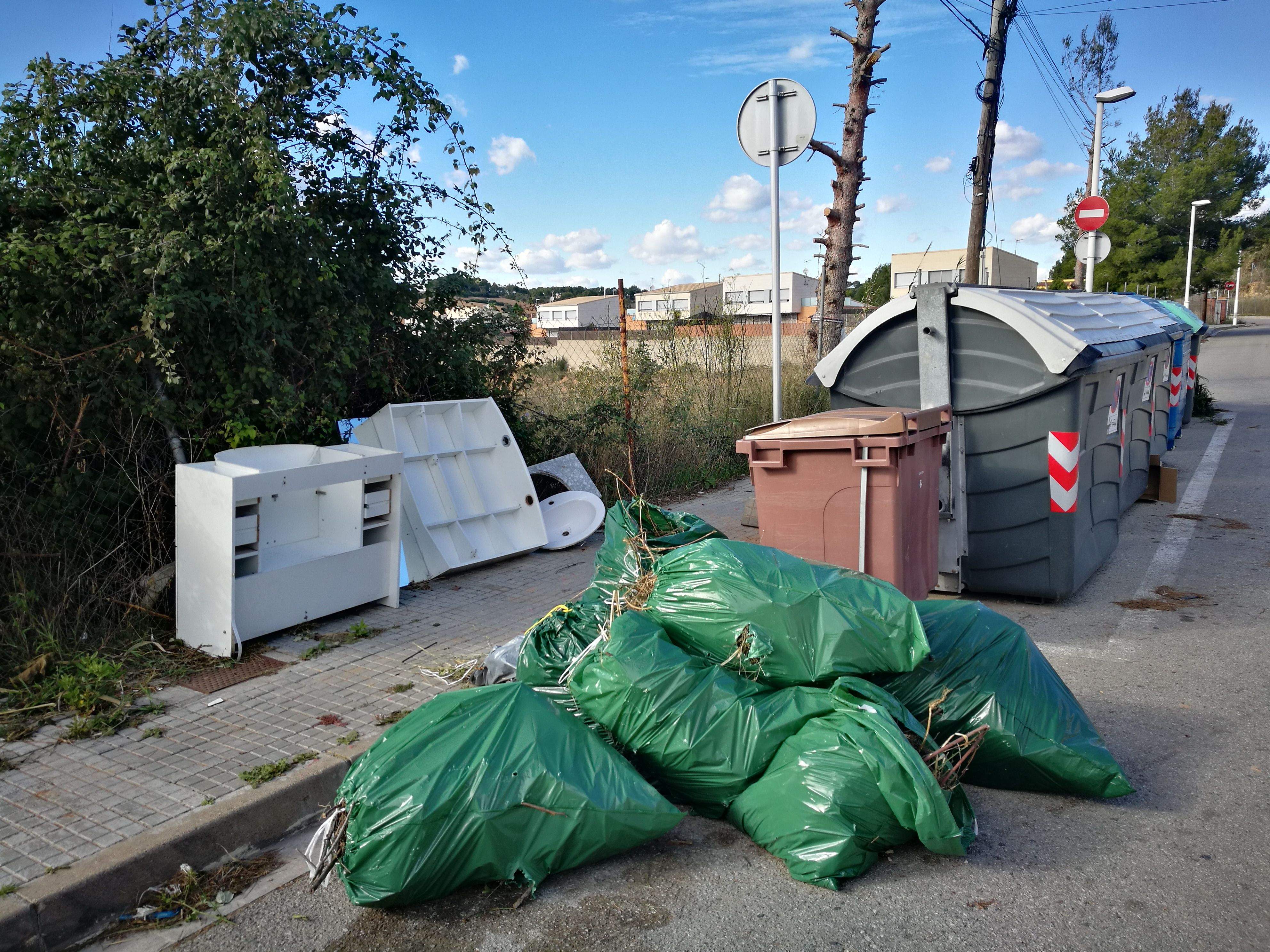 Restes d'escombraries i d'un lavabo al voltant d'uns contenidors de Can Serrafossà. FOTO: Redacció