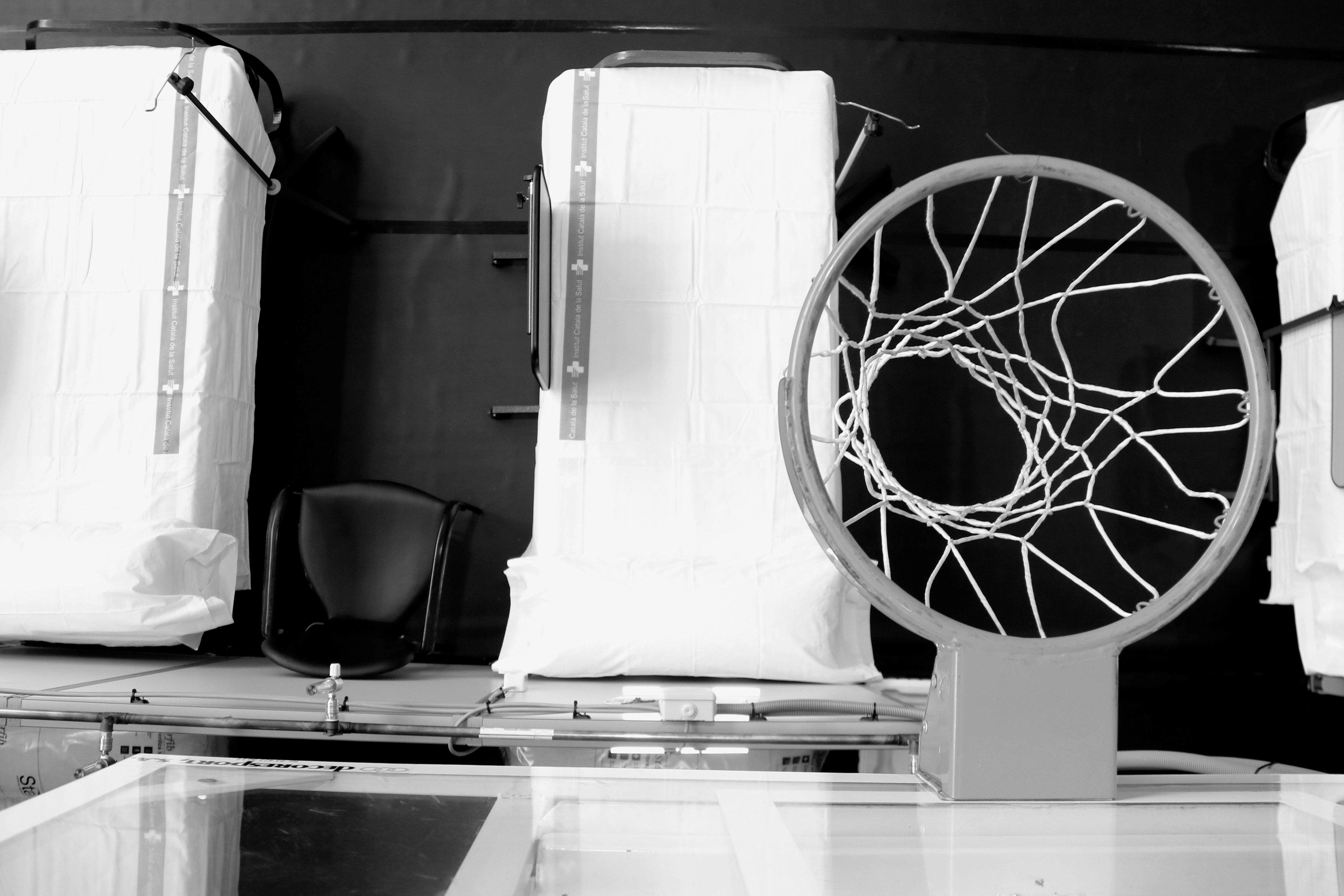 Llits de l'hospital de campanya del pavelló de l'Institut Guttmann, amb una cistella de bàsquet. FOTO: ACN