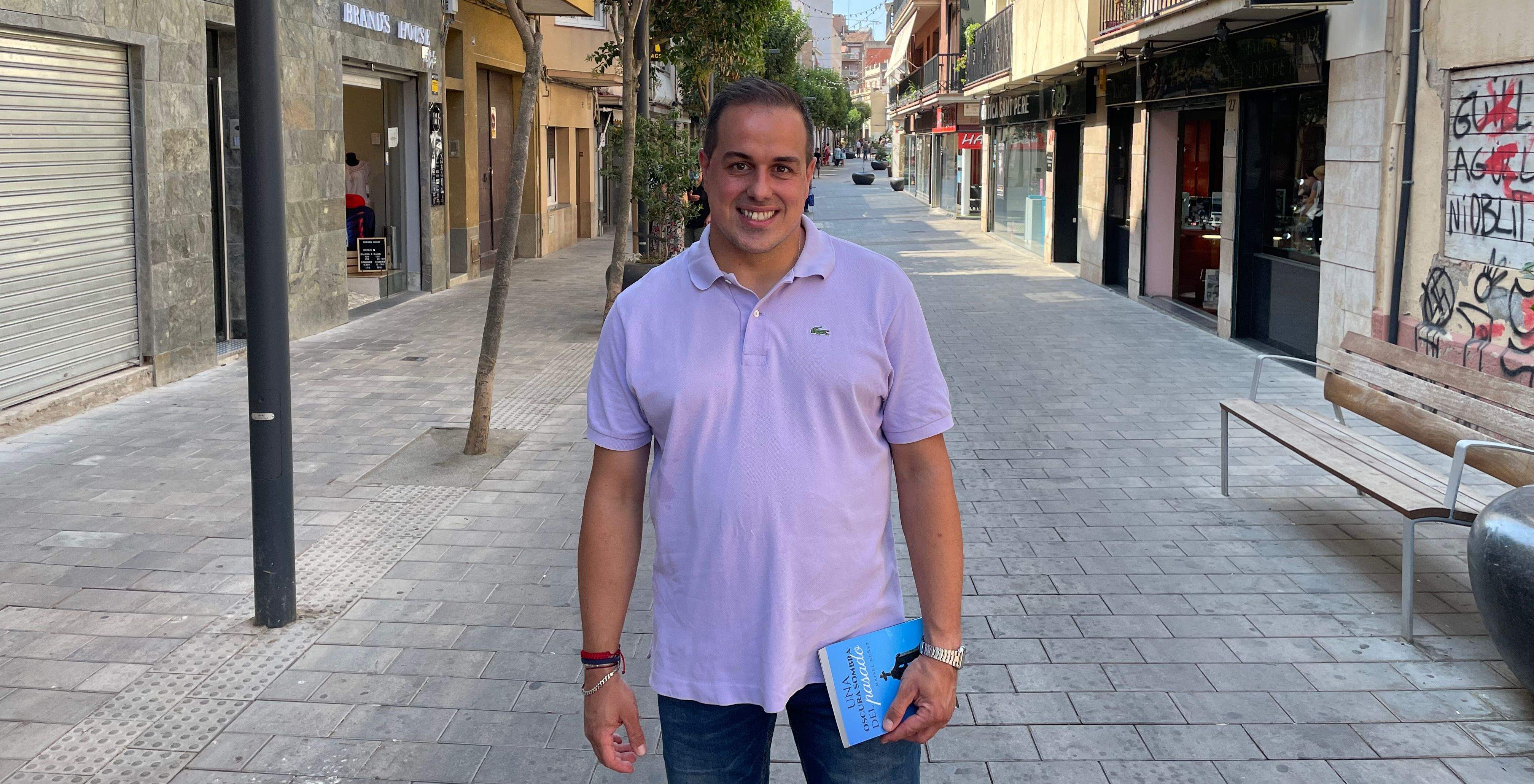 Maikel Núñez al carrer Pere Esmendia de Rubí, amb un exemplar de seva primera novel·la. FOTO: NHS 