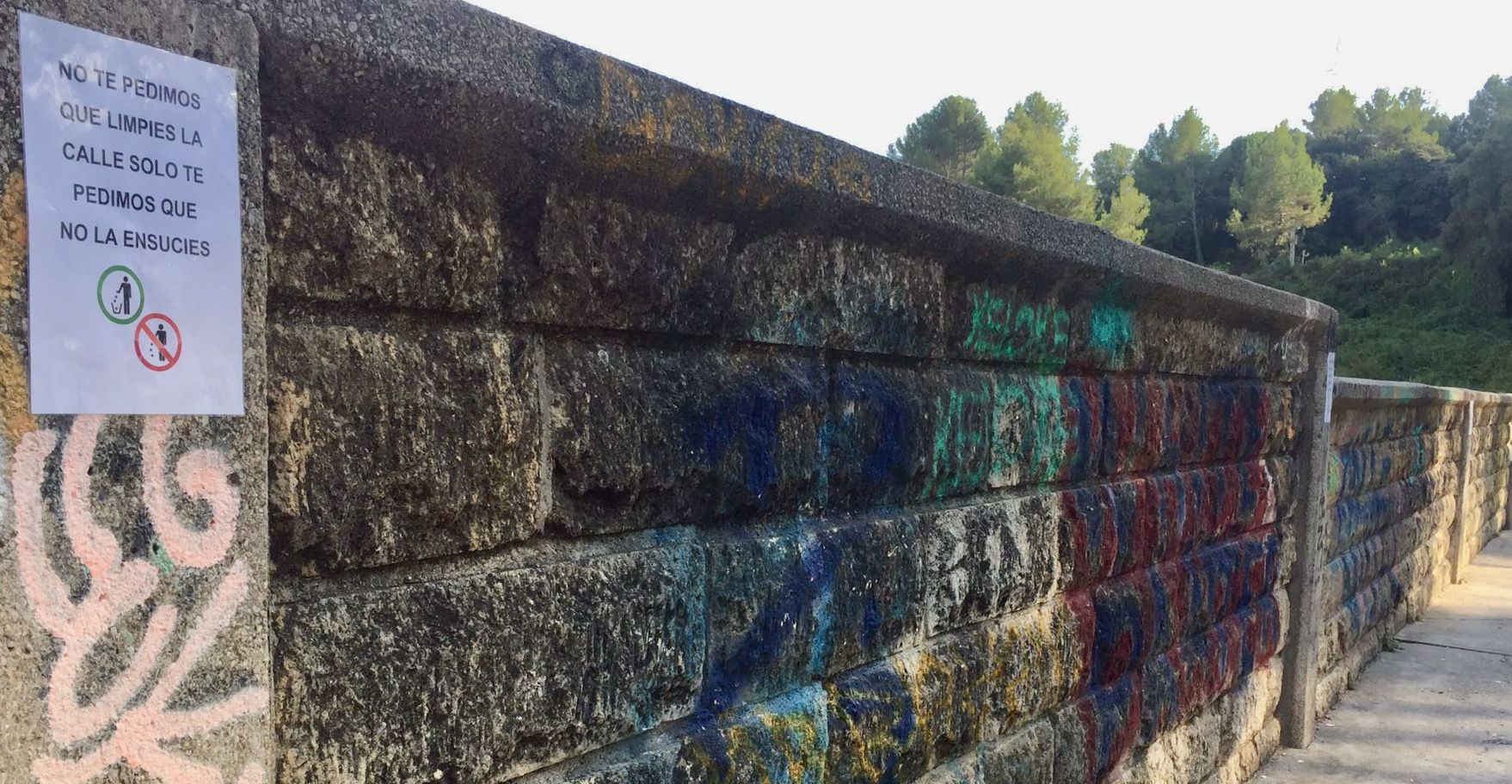 Mur de les antigues instal·lacions de les piscines de Castellnou, amb un cartell enganxat pels veïns on demanen civisme. FOTO: Cedida