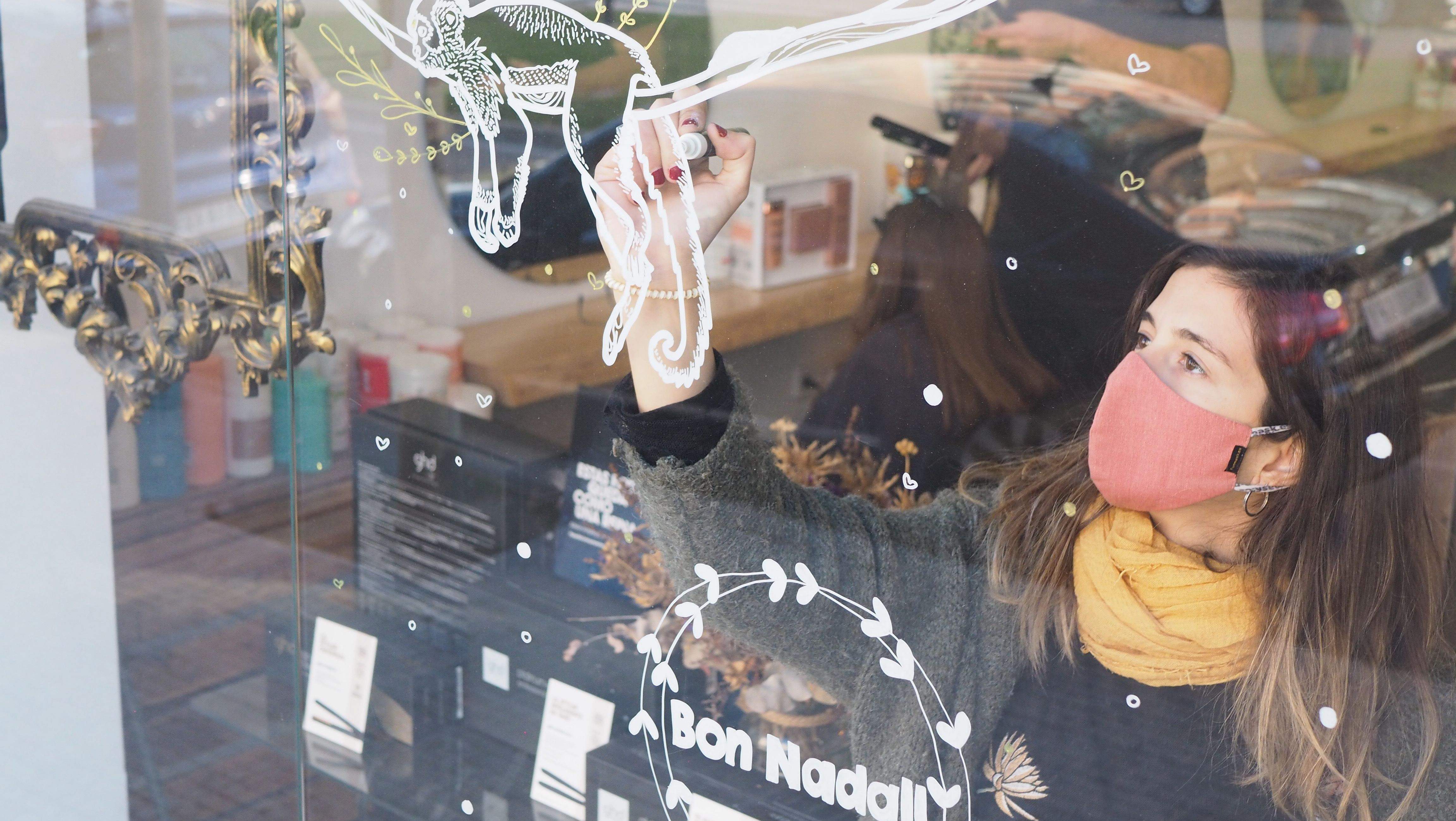 L'artista local Nataxa Ruzafa decorant un aparador de Rubí en la iniciativa NadalARTS de l'any passat. FOTO: Joan Pol Sala 