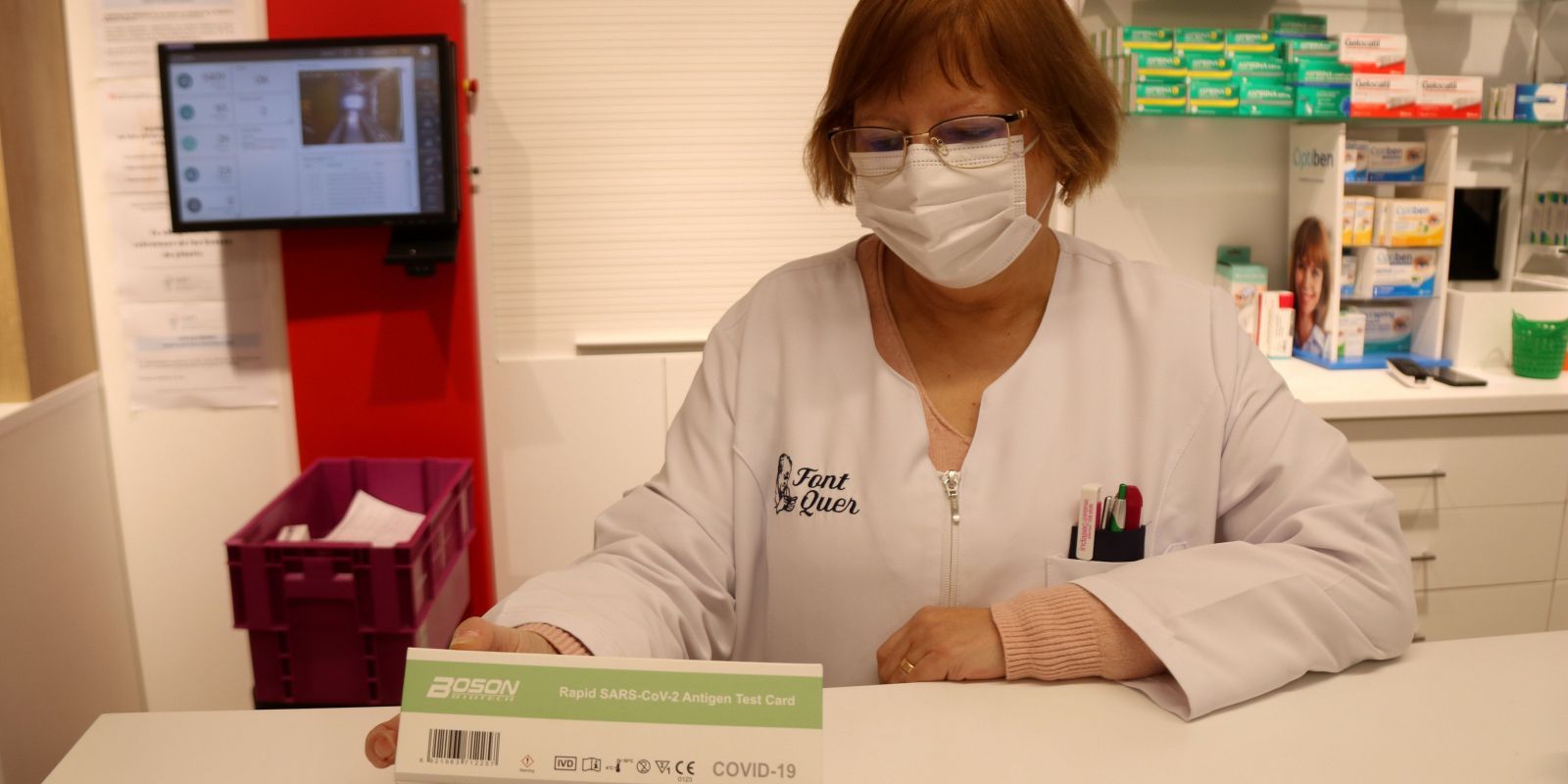Una farmacèutica amb una caixa d'un test d'antigen en una farmàcia. FOTO: Mar Rovira (ACN)