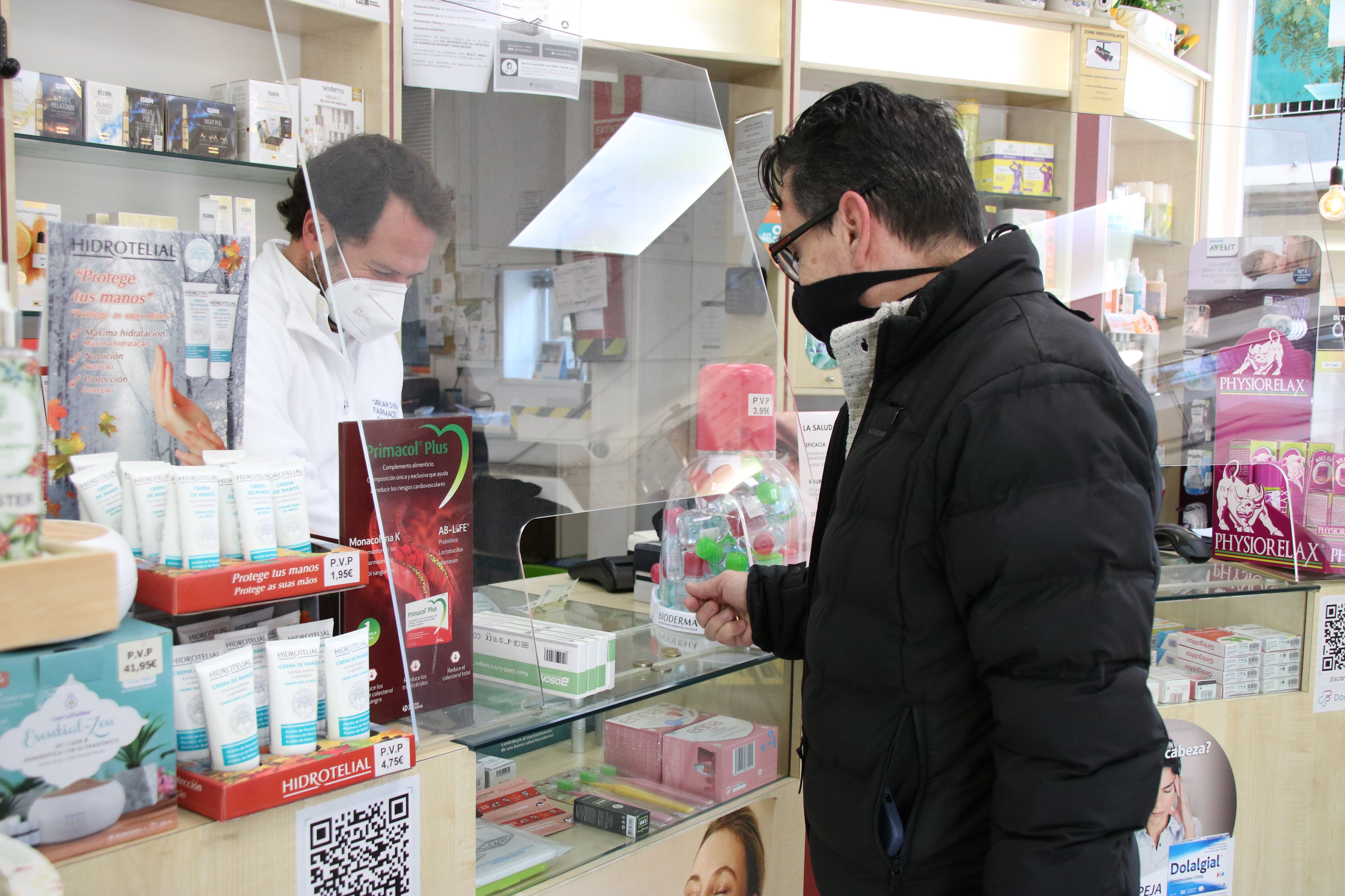 UUna persona amb mascareta comprant tests d'antígens en una farmàcia. FOTO: Carola López (ACN)