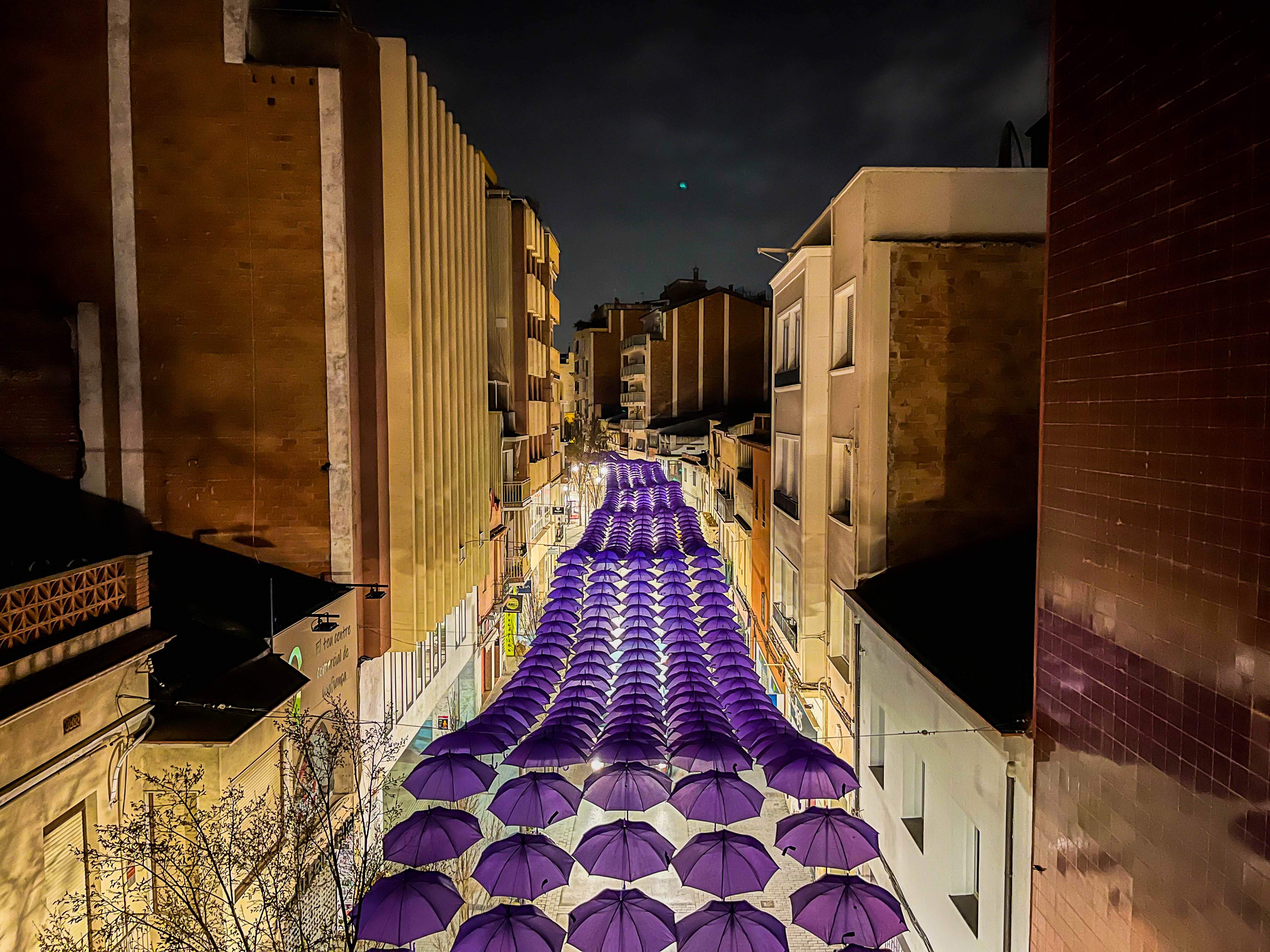 Vista dels paraigües liles a l'illa de vinanats de nit. FOTO: Umbrella Sky Project