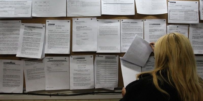 Una dona mira les ofertes de feina en un tauler d'anuncis. FOTO: Artur Ribera