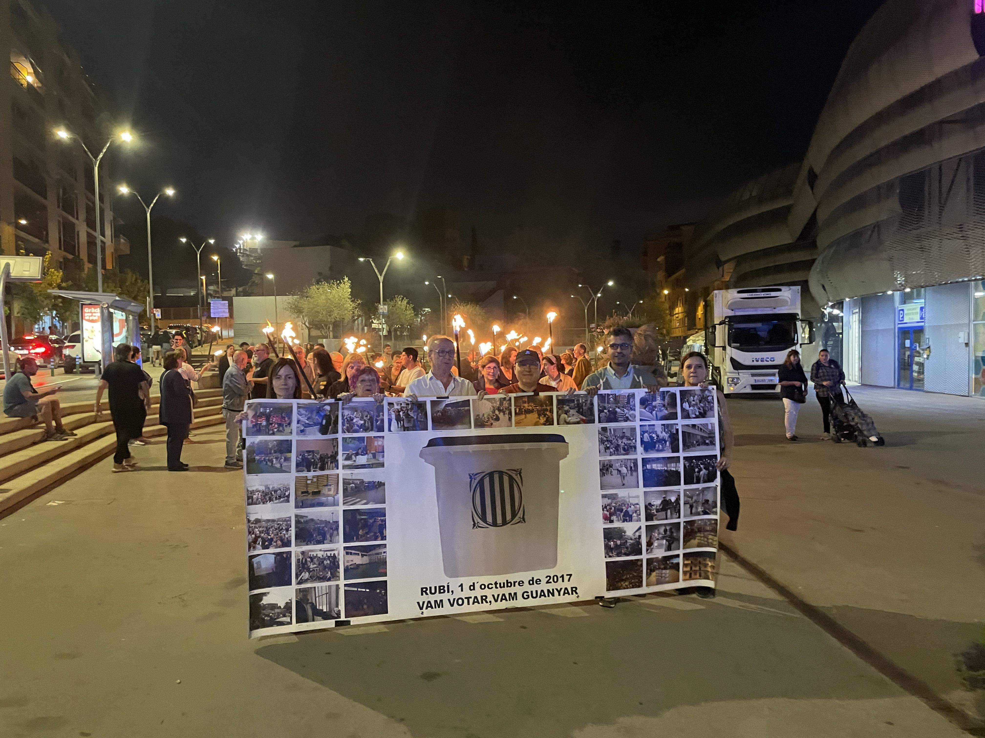 Desenes de persones commemoren l'1 d'octubre amb una marxa de torxes. FOTO: Estela Luengo