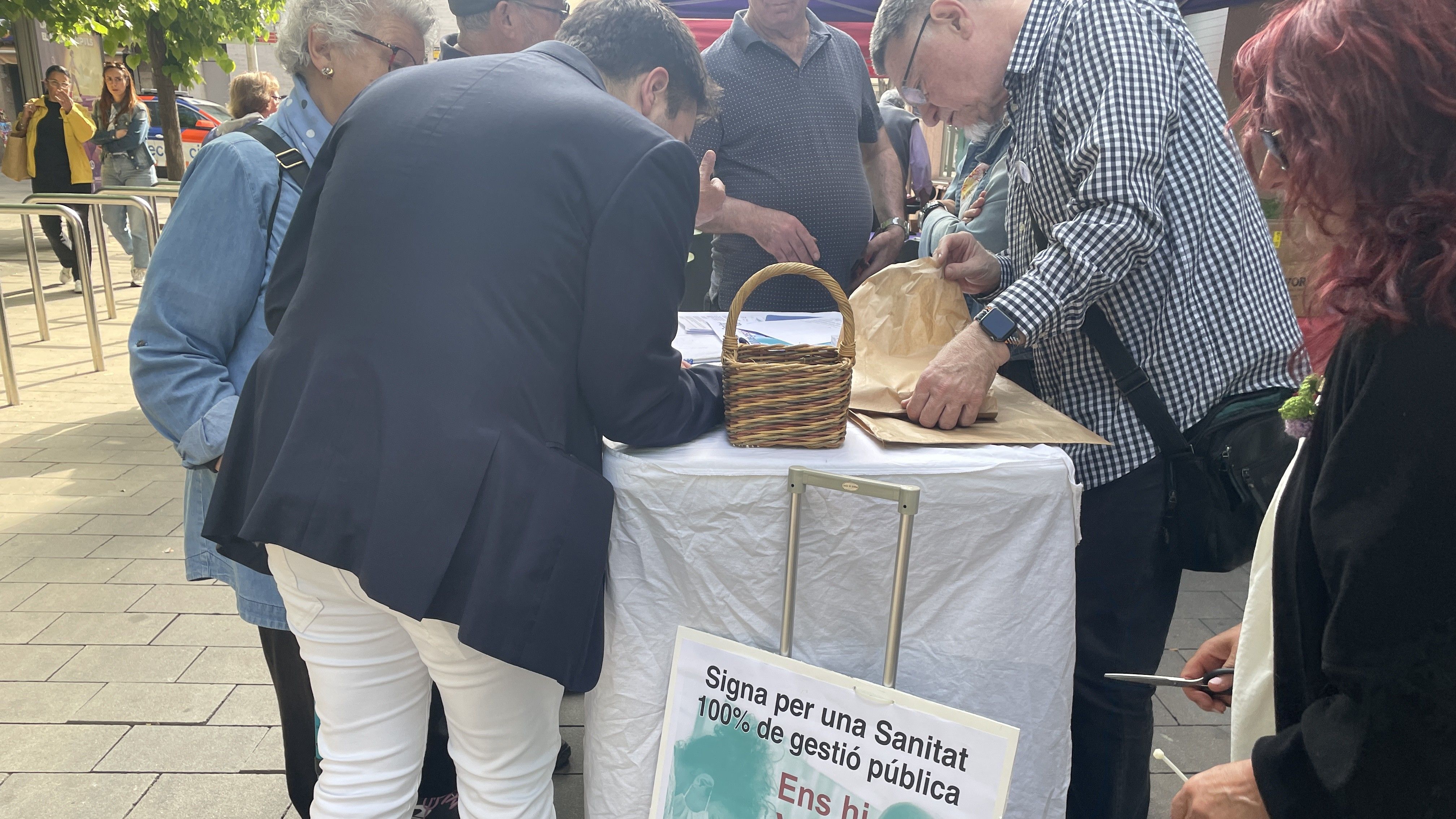 Dues persones signant a la paradeta de la Coordinadora el dia de Sant Jordi FOTO: Marta Casas